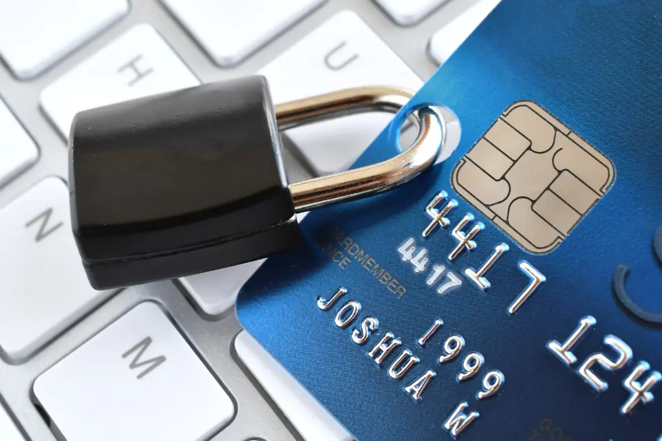 Image of a credit card on a keyboard with a lock on the debit card.